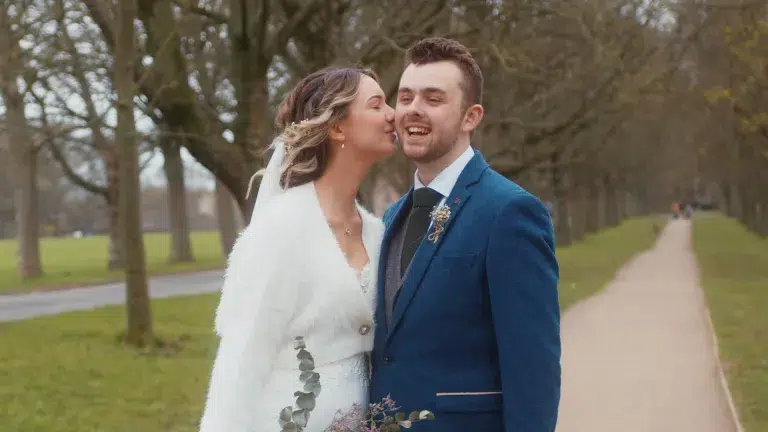 Bride and groom smiling at each other, surrounded by nature